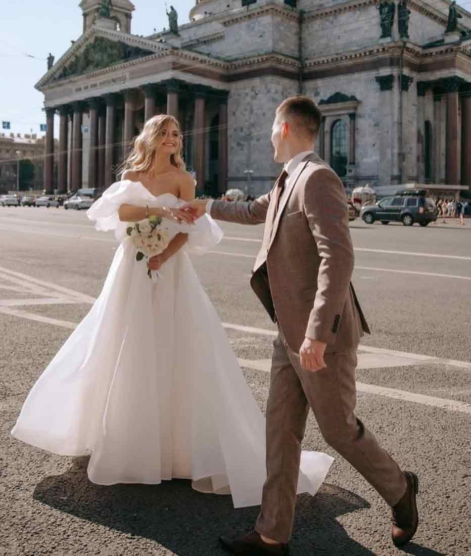 Сouple wearing a white gown and a brown suit