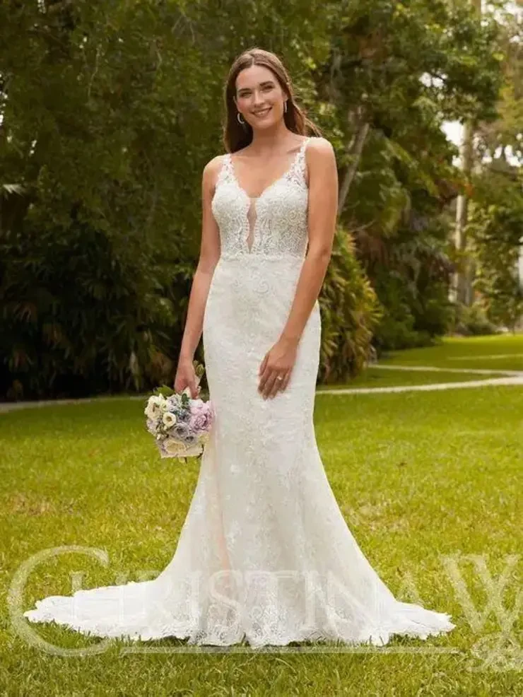 Model is wearing a fit and flare lace sleeveless wedding dress