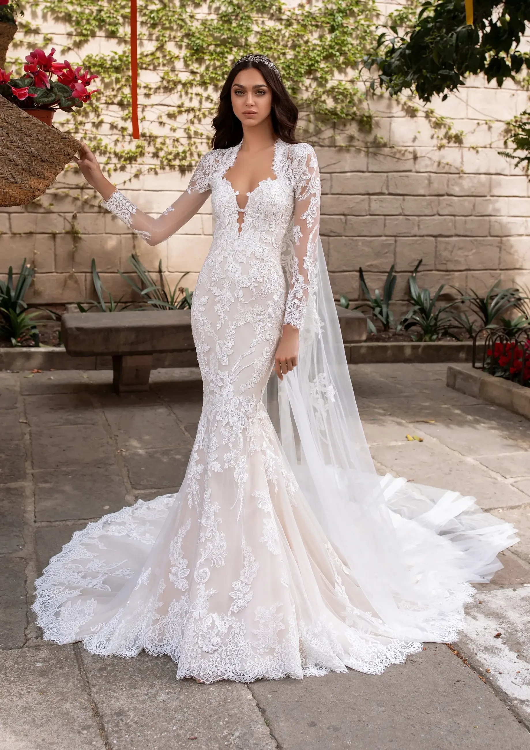 Model is wearing a lace mermaid wedding dress with a sweetheart neckline