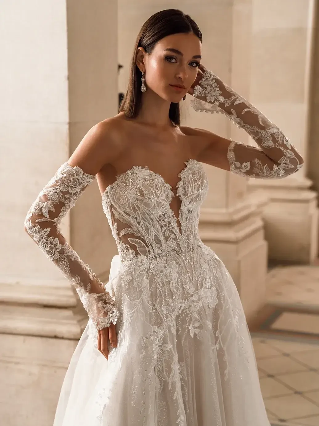 model is wearing a strapless a-line wedding dress with long sleeve detachable sleeves
